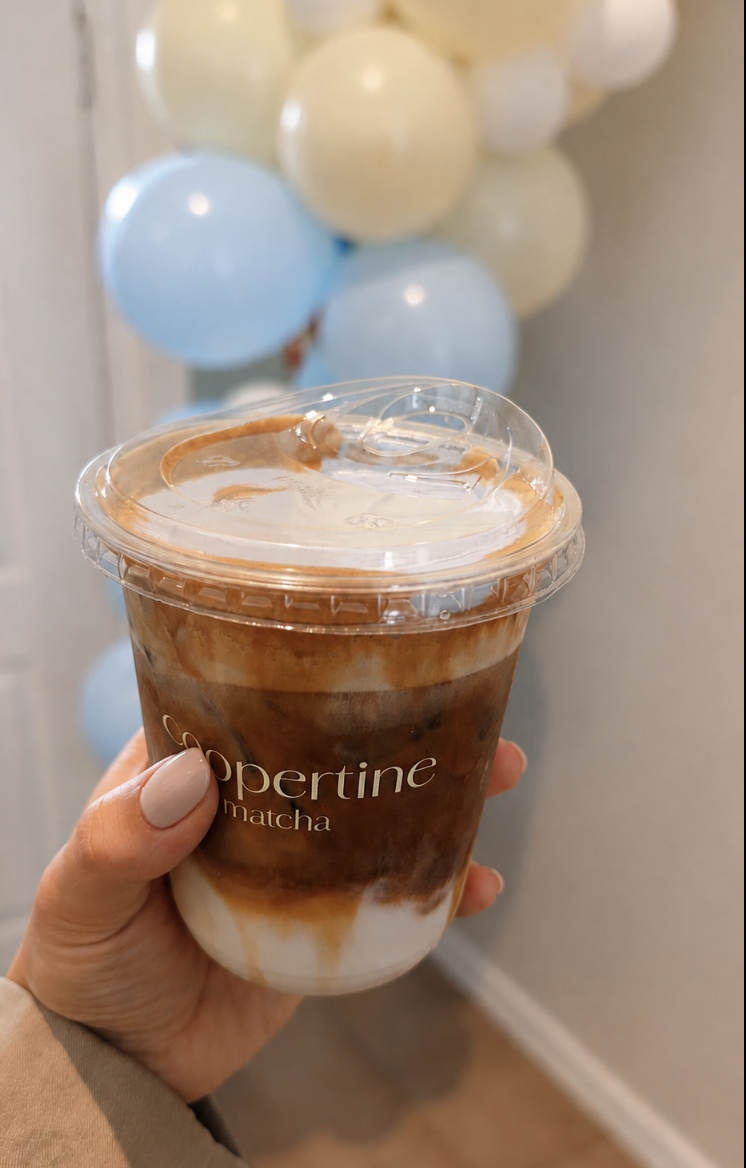 Iced latte against yellow and blue balloons